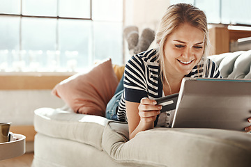 Image showing Tablet, online shopping and girl happy with credit card payment online on living room couch. Relaxed woman checking card details with satisfied smile for ecommerce transaction on home sofa.