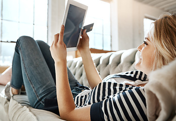 Image showing Woman, tablet and credit card for ecommerce, online shopping or purchase on living room sofa relaxing at home. Female shopper banking on touchscreen with bank card for purchase, app or sale on couch