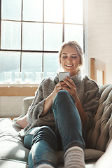 Image showing Woman, sofa and phone with smile, chat and communication on internet to relax in lounge. Girl, couch and texting on social network, mobile tech or streaming video for comedy, meme and happy in house