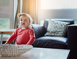 Image showing Children, baby and a girl in the living room of her home with mockup or flare looking curious while standing alone. Kids, development and lifestyle with a cute female child in a house during the day