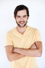 Image showing Happy, smile and portrait of a man with casual fashion and tshirt with vertical white background. Isolated, arms crossed and model smiling and feeling positive with joy alone looking comfortable