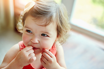 Image showing Happy, baby and girl playing in her home, looking, taste and curious while biting her hand. Child, smile and child development by little girl watching, calm and content in a living room alone