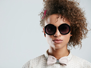 Image showing Black woman, fashion and sunglasses portrait in studio for funky, quirky and trendy people style. Assertive face of fashionista person in isolated gray background for marketing mockup.