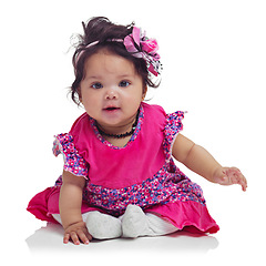 Image showing Cute, happy and portrait of a baby girl sitting isolated on a white background in a studio. Girly, playful and innocent, adorable and small child smiling with happiness on a studio background