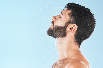 Image showing Shower, man and cleaning face with water and hygiene, grooming and skincare against blue studio background. Clean, model profile with water drops and facial, natural treatment and cosmetic mockup