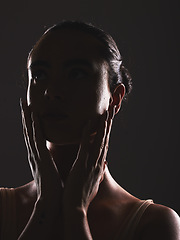 Image showing Woman, beauty and face silhouette in dark fantasy, cosmetics and dream aesthetics. Shadow, black background and model headshot while touching facial skin in mystery, studio background and erotic body