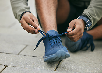Image showing Fitness, hands and black man tie shoes in city and getting ready for running, workout or exercise. Wellness, sports and male runner tying sneaker lace and preparing for training on street outdoors.