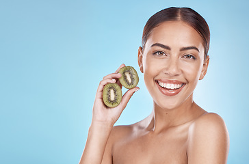 Image showing Skincare, kiwi and portrait of beauty woman with natural smile and healthy glow for marketing. Wellness, happy and self care model with fruit for cosmetic advertising in blue studio mockup.