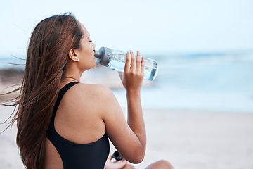 Image showing Water drink, thirsty and woman at the beach to relax, holiday peace and zen at the ocean in Hawaii. Hydration, calm and girl drinking from a bottle at the sea for a travel vacation in summer