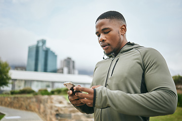 Image showing Fitness, phone or black man on social media in city to relax in training, exercise or workout with in New York. Social networking, wellness or healthy athlete texting, chat or typing online on break