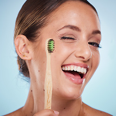 Image showing Brushing teeth, dental and woman with toothbrush, wink and beauty, oral health and fresh breath with studio background. Mouth wellness, Invisalign portrait and teeth whitening with bamboo brush.