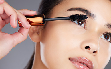 Image showing Face, beauty makeup and woman with mascara in studio isolated on gray background. Cosmetics, aesthetics and closeup of young female model with brush, tool or product for care of eyelashes or wellness