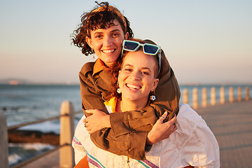 Image showing Lesbian, portrait and couple of friends at the beach in piggyback, support and happy for lgbtq love. Sunset, sea and smile of women or gay people on summer date with pride, freedom and gen z holiday