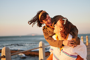 Image showing Women, gay couple and piggyback by the ocean coast with smile for happy relationship and fun pride in the outdoors. Lesbian woman on back ride with partner laughing in joy and happiness by the beach