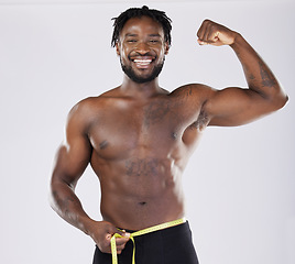 Image showing Muscular black man, tape measure and flexing in fitness for weight loss or dieting isolated on a grey background. Portrait of happy sporty male with smile for healthy lifestyle, fit body or muscle