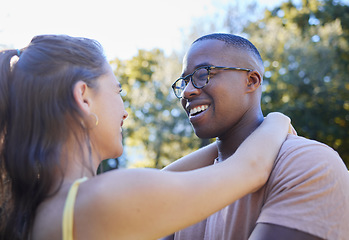 Image showing Interracial couple, smile and hug for love, care or embracing relationship together in a nature park. Happy black man hugging woman and smiling in happiness for romance, embrace or support outside