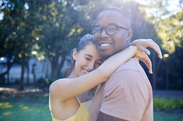 Image showing Summer, love and interracial with a couple bonding outdoor together in a park or natural garden. Nature, diversity and romance with a man and woman hugging while on a date outside in the countryside