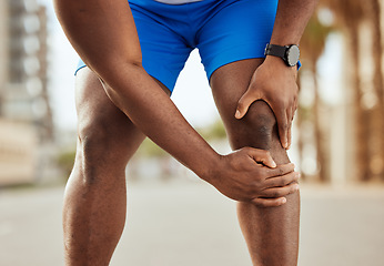 Image showing Fitness, pain in knee and hands of black man with muscle ache, joint pain and injury after running in city. Sports, body wellness and male athlete rest after workout, marathon training and exercise