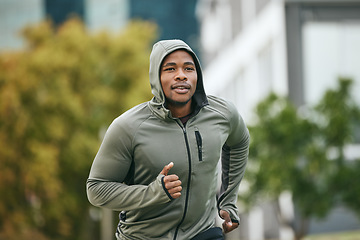Image showing Fitness, runner or black man running in city for body training, exercise or workout with focus in Miami, Florida. Freedom, mindset or healthy sports athlete with wellness goals, motivation or mission