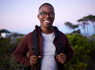 Image showing Portrait, hiking and nature with a black man outdoor for health, freedom or adventure in the evening. Hike, hobby and recreation with a handsome young male hiker carrying a backpack alone outside