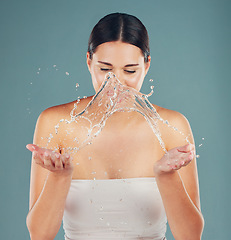 Image showing Skincare, beauty and water in hands of a woman on a studio background for dermatology. Health splash and wellness of a happy aesthetic model person cleaning skin or body for facial spa treatment