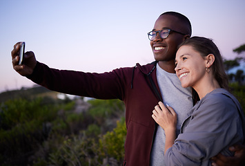 Image showing Interracial couple, phone and smile for selfie, travel or adventure trip together in the nature outdoors. Happy man holding smartphone and taking a photo with woman smiling in happiness for journey