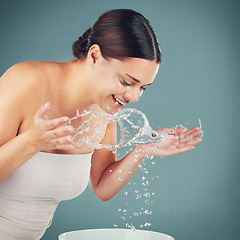 Image showing Water splash, woman and skincare while washing face for dermatology wellness on a studio background. Health and glow of a happy aesthetic model person cleaning skin or body for facial spa treatment