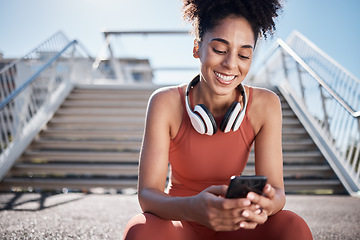 Image showing Fitness, phone and black woman in city on break on social media, texting or web browsing after exercise. Sports, cellphone and happy female athlete by stairs with 5g mobile smartphone for networking.