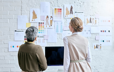 Image showing Fashion, designer teamwork and back of women in workshop looking at designs on wall. Collaboration, small business and senior female tailors in boutique planning and discussing color choice or sketch