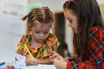 Image showing Creative kids sitting in a preschool institution, draw and have fun while they get an education