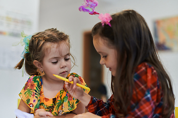 Image showing Creative kids sitting in a preschool institution, draw and have fun while they get an education