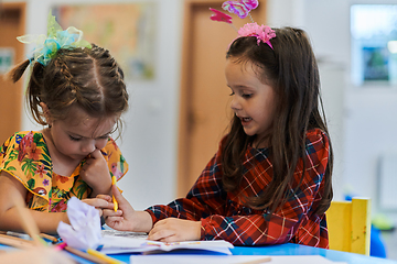 Image showing Creative kids sitting in a preschool institution, draw and have fun while they get an education