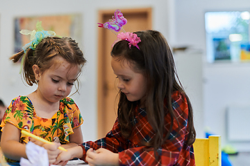 Image showing Creative kids sitting in a preschool institution, draw and have fun while they get an education