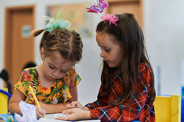 Image showing Creative kids sitting in a preschool institution, draw and have fun while they get an education