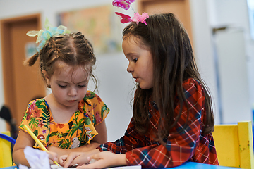 Image showing Creative kids sitting in a preschool institution, draw and have fun while they get an education