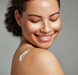 Image showing Face, skincare and back of woman with cream in studio isolated on gray background. Cosmetics, beauty dermatology and happy female model with lotion, creme or moisturizer for healthy skin or wellness.