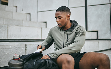 Image showing Exercise, workout and black man on stairs, relax and training for fitness, wellness and health. African American male, athlete and looking in bag on steps, outdoor and sportswear for cardio or energy