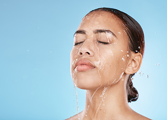 Image showing Woman, face skincare or water splash on blue background studio for healthcare wellness, Brazil hygiene maintenance or self care grooming. Beauty model, showering or wet water drop for facial cleaning