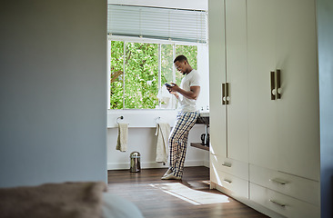 Image showing Phone, bathroom and black man in home on social media, texting or internet browsing. Relax, cellphone or happy male holding mobile smartphone for web scrolling, networking or messaging alone in house