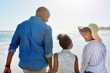 Image showing Black family, beach and walking during summer on vacation or happy holiday laughing and enjoying the scenery at the ocean. Sea, water and parents with daughter, child or kid with childhood freedom