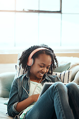 Image showing Digital tablet, sofa and girl with headphones relaxing while listening to music, radio or podcast. Rest, technology and African child watching a video or movie on mobile device in living room at home