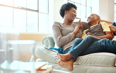 Image showing Black family, son and mother relax on a sofa, laugh and happy while bond in their home together. Mom, love and boy resting with parent, content and playful while sitting and talking in living room