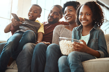 Image showing Black family watching tv on sofa for movie, film and cartoon together, bonding and quality time in living room. Popcorn, kids television show of people, mother and father with kids, on couch watching