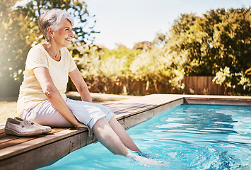 Image showing Happy elderly woman with her feet in the pool while on a vacation, adventure or outdoor trip in summer. Relax, smile and senior lady in retirement by swimming pool at a holiday resort in Australia.