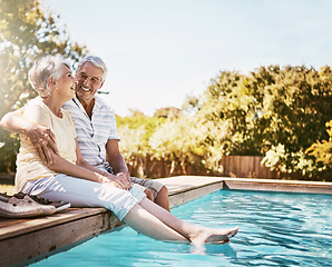 Image showing Senior couple, hug and smile by swimming pool for relax, love or quality bonding time together on summer vacation. Happy elderly man holding woman relaxing with feet in water by the poolside outside