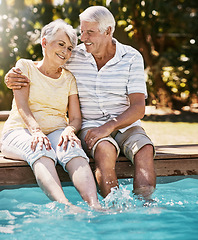 Image showing Elderly couple, hug and smile by swimming pool for relax, love or quality bonding time together on summer vacation. Happy senior man holding woman relaxing with feet in water by the poolside outside