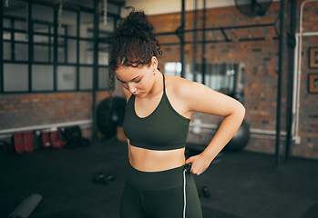 Image showing Fitness, exercise and woman at gym to check body progess after training for health, balance and wellness. A young sports female or athlete strong and healthy while on diet and active to lose weight