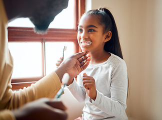 Image showing Dental health, father and daughter brushing teeth in a bathroom for hygiene, grooming and bonding. Oral, care and girl with parent, teeth and cleaning while having fun, playful and smile at home