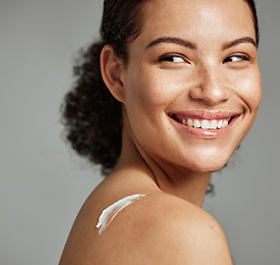 Image showing Face, skincare and woman with back cream in studio isolated on gray background. Beauty cosmetics, thinking and happy young female model with lotion, creme or moisturizer for healthy skin or wellness