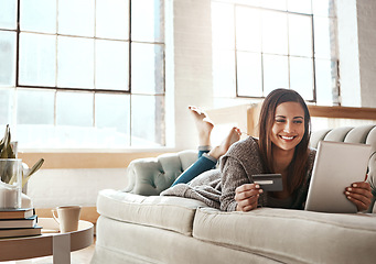 Image showing Online shopping, ecommerce and credit card with digital tablet by woman on a sofa, happy and relax. Online banking, debit card and girl checking credit score, savings or membership in a living room